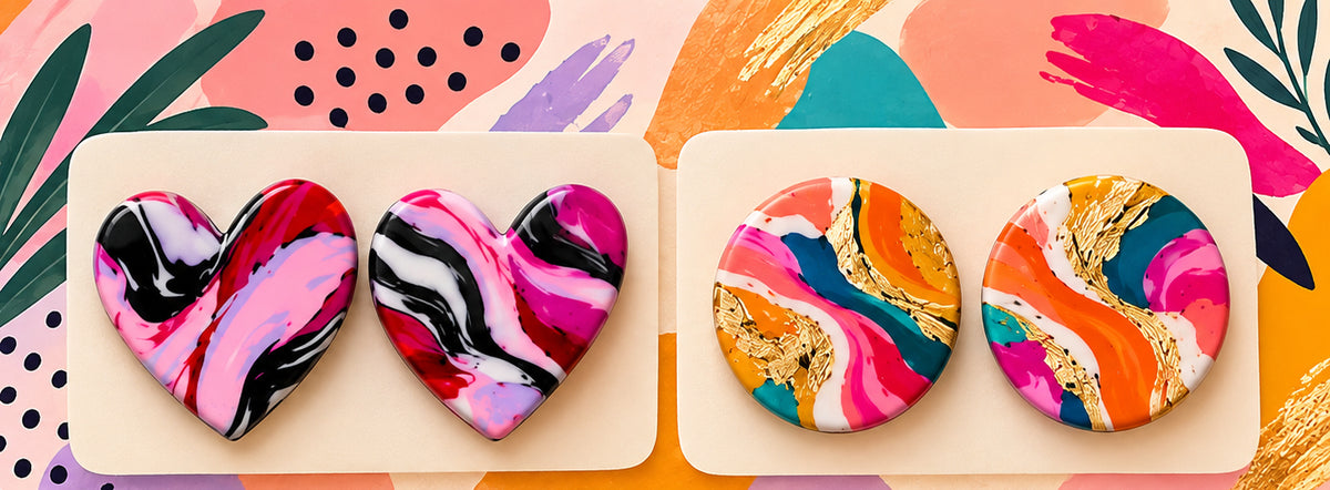 Marbled heart and gold-veined round polymer clay earrings on a colorful background